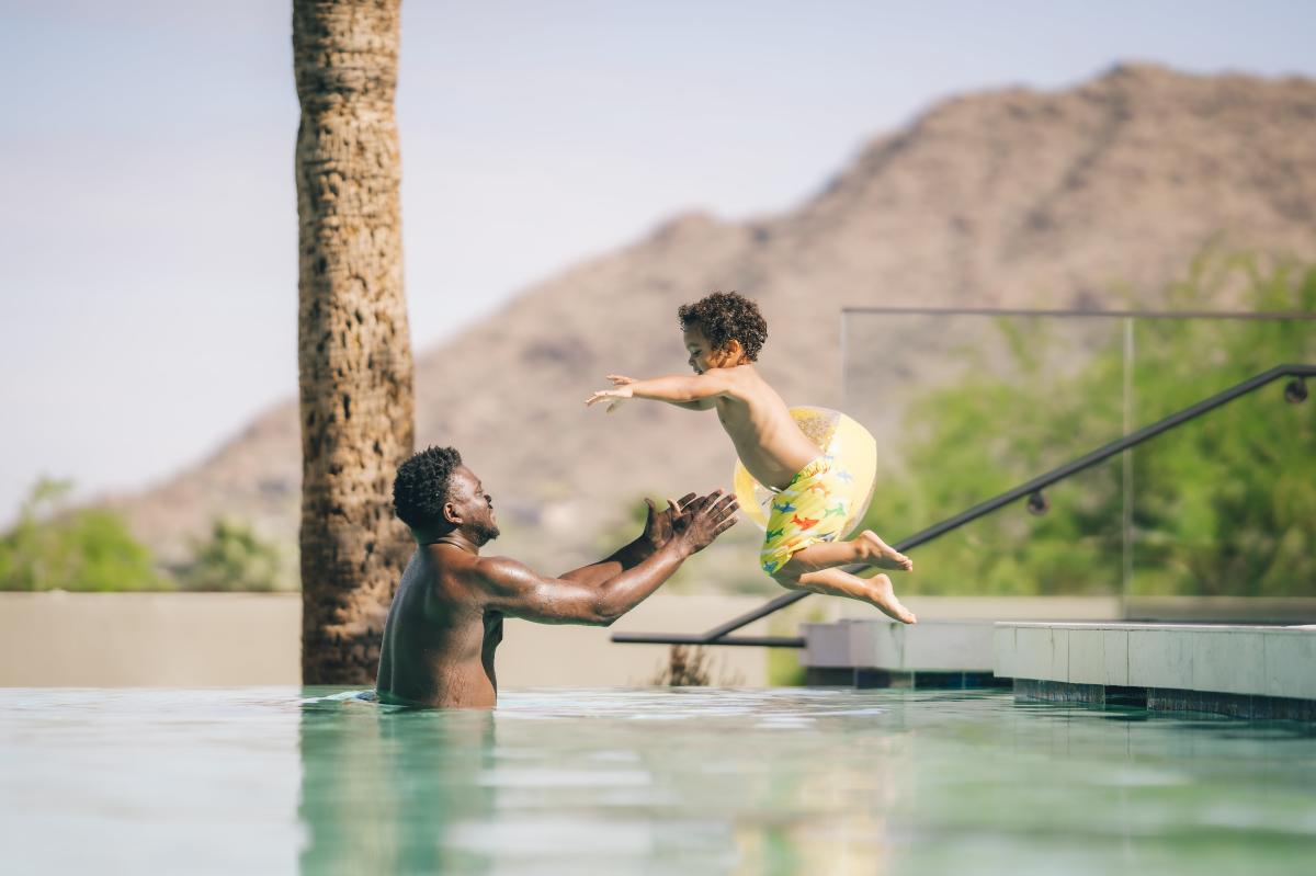 Father and son poolside at Sanctuary Camelback Mountain, a Gurney's Resort & Spa